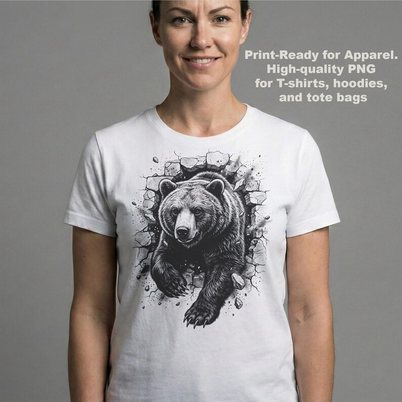 May include: White t-shirt featuring a black and white illustration of a bear breaking through a wall. The text on the shirt reads "Print-Ready for Apparel. High-quality PNG for T-shirts, hoodies, and tote bags."