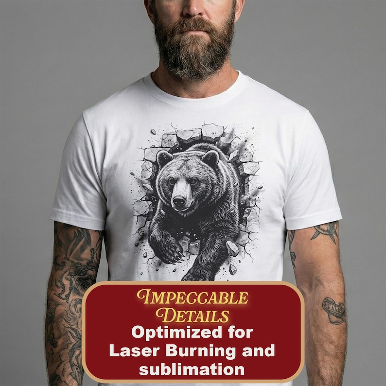 May include: White t-shirt featuring a detailed black and white illustration of a bear breaking through a wall. The shirt includes the text "Impeccable Details Optimized for Laser Burning and sublimation" in a maroon rectangle.