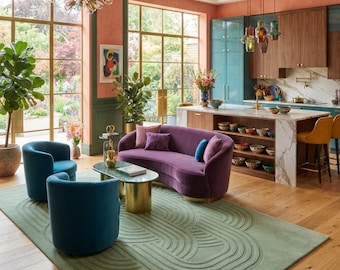 May include: A sage green area rug with a raised, concentric oval pattern sits on a light wood floor. The rug is positioned beneath a curved purple sofa, two teal armchairs, and an oval coffee table with a green stone top and gold base.