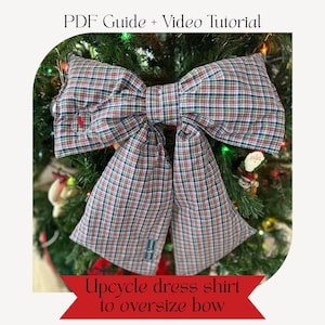 May include: A large bow made from a plaid dress shirt, displayed on a Christmas tree. The bow features red, green, blue, and white colors. Text at the top reads "PDF Guide + Video Tutorial" and at the bottom "Upcycle dress shirt to oversize bow."