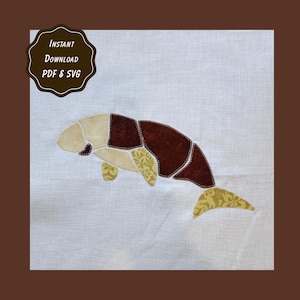 Puede incluir: Un panel de tela blanca con una aplicación de manatí hecha de piezas de tela marrón, beige y amarilla estampada con costuras visibles. Una insignia festoneada de color marrón oscuro en la esquina superior izquierda contiene el texto Instant Download PDF & SVG.