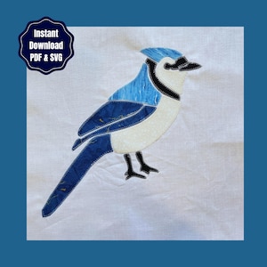 May include: A fabric appliqué of a blue jay bird featuring shades of blue, white, and black stitching on a white background. The design includes a dark blue badge in the upper left corner with the text Instant Download PDF & SVG.