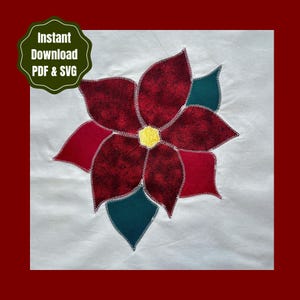 May include: A white fabric square featuring a central poinsettia appliqué with dark red patterned petals, solid red petals, dark green leaves, and a yellow center, all outlined with white zigzag stitching. Text reads: Instant Download PDF & SVG.