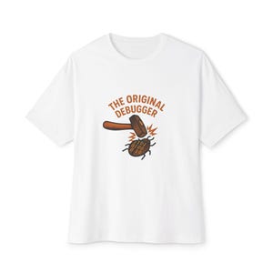 Peut inclure: T-shirt blanc avec l'inscription "THE ORIGINAL DEBUGGER" et une image de dessin animé d'un marteau frappant un bug. Le bug porte du code binaire sur le dos. Le design est marron et orange.