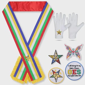 Puede incluir: Una banda ceremonial con rayas rojas, amarillas, verdes, blancas y azules, con un emblema de estrella y flecos amarillos. Incluye guantes blancos con una estrella, un parche de estrella, un parche de mariposa OES y un parche redondo con el texto I will always be my Sister's Keeper OES Order of the Eastern Star.