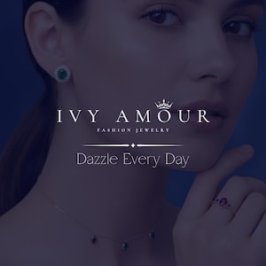 May include: A woman wearing fashion jewelry, including a necklace with three colored gemstones, a ring with a red gemstone, and a pair of emerald earrings. The image includes the text "IVY AMOUR" and "Dazzle Every Day".