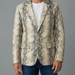May include: A beige and gray snakeskin-patterned blazer with a two-button closure, two front pockets, and a notched lapel. The blazer is worn over a white t-shirt and blue jeans.