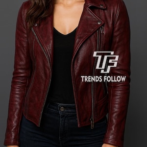 May include: A burgundy leather jacket with a classic biker style, featuring a notched collar, asymmetrical zipper, and zippered pockets. The jacket is worn over a black top and paired with dark blue jeans. The text "TRENDS FOLLOW" is visible.