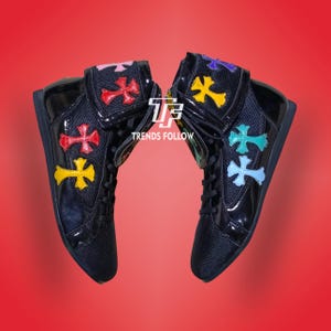 Può includere: Paio di sneakers alte nere con disegni a croce colorati. Le sneakers hanno una finitura lucida e presentano croci rosse, gialle, rosa, blu e verdi. Il testo "TRENDS FOLLOW" è visibile.