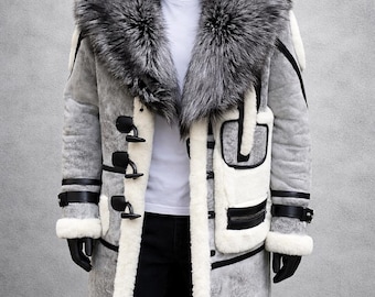 May include: A gray, long coat with a large, fluffy, silver-gray fur collar. The coat features black toggle closures, white trim, and black leather accents. The mannequin is wearing a white shirt and black gloves.