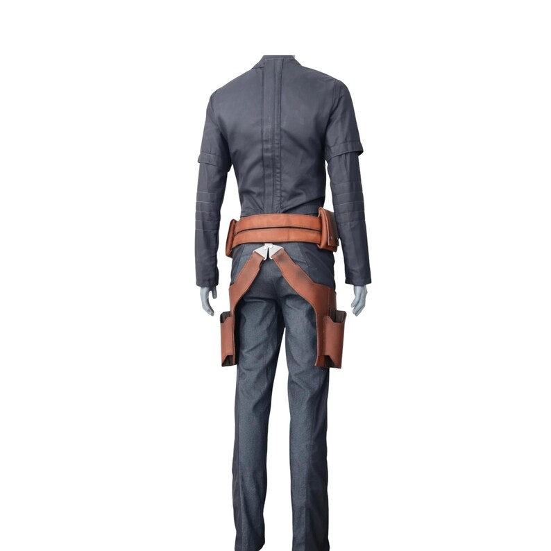 K&ouml;nnte beinhalten: Grauer Overall mit braunem G&uuml;rtel und holsterartigen Taschen. Das Outfit hat lange &Auml;rmel und einen hohen Kragen. Der G&uuml;rtel und das Holster sind aus braunem, leder&auml;hnlichem Material. Das Outfit ist als Kost&uuml;m gestaltet.