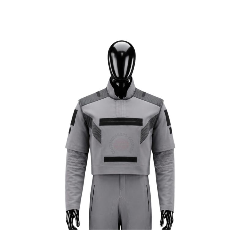 May include: A gray costume with black accents, featuring a high collar and short sleeves. The outfit includes a cropped top with geometric designs and matching pants. The costume is displayed on a black mannequin.