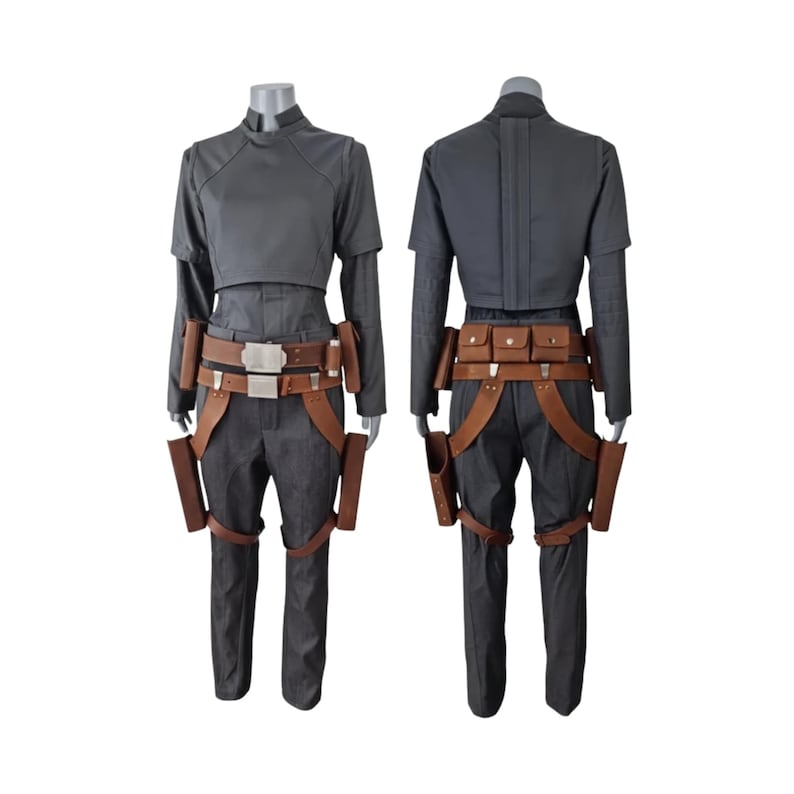 K&ouml;nnte beinhalten: Ein zweiteiliges Kost&uuml;m mit einem grauen Oberteil und einer Hose. Das Oberteil hat kurze &Auml;rmel und einen hohen Kragen. Die Hose ist dunkelgrau. Das Kost&uuml;m enth&auml;lt einen braunen G&uuml;rtel mit Taschen und Halftern. Das Kost&uuml;m wird auf einer Schaufensterpuppe pr&auml;sentiert.