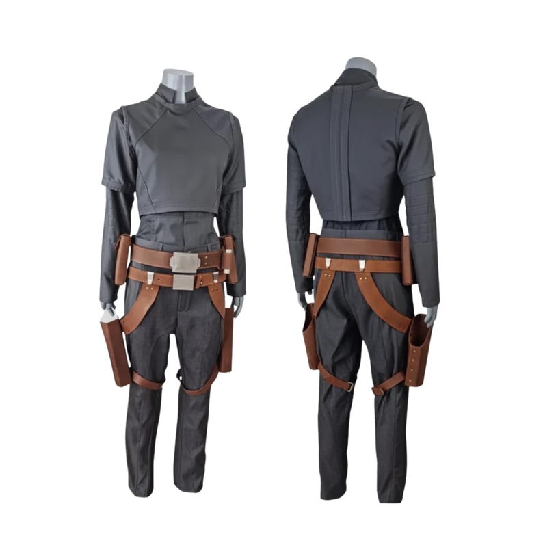 K&ouml;nnte beinhalten: Ein zweiteiliges Kost&uuml;mset auf einer Schaufensterpuppe. Das Set umfasst ein dunkelgraues, kurzes Oberteil und eine passende Hose. Ein brauner Lederg&uuml;rtel mit silberner Schnalle und Zubeh&ouml;r im Holster-Stil vervollst&auml;ndigen das Outfit. Ideal f&uuml;r Cosplay.