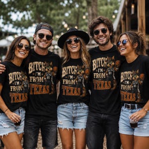 May include: A group of people wearing black t-shirts with a graphic of a cartoon character in a cowboy hat holding a basketball. The text on the shirts reads "BITCH I'M FROM TEXAS" with the number "21".