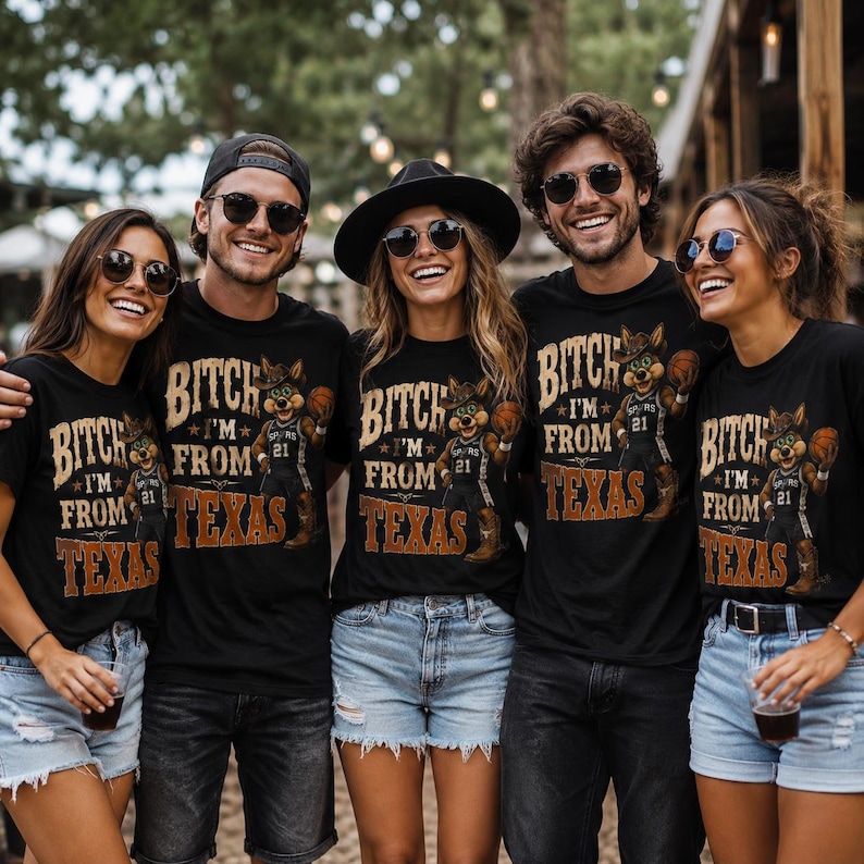 May include: A group of people wearing black t-shirts with a graphic of a cartoon character in a cowboy hat holding a basketball. The text on the shirts reads "BITCH I'M FROM TEXAS" with the number "21".
