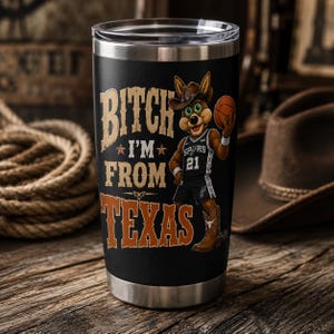 May include: Black stainless steel tumbler with the text "Bitch I'm From Texas" in tan and orange. A cartoon jackrabbit wearing a cowboy hat and Spurs jersey holds a basketball. The tumbler has a silver rim.