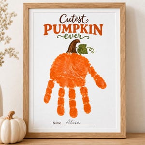 Pode incluir: Uma impressão emoldurada com o texto Cutest PUMPKIN ever em letras castanhas e cor de laranja. Abaixo do texto, encontra-se uma impressão de mão cor de laranja em forma de abóbora com um caule castanho e uma folha verde. O nome Alisa está escrito.