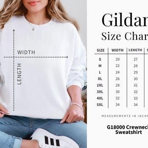 May include: White Gildan crewneck sweatshirt with a size chart. The chart displays measurements in inches for width, length, and sleeve length, ranging from size small to 5XL. The sweatshirt is G18000.