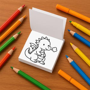 An open mini coloring book shows a line-art illustration of a cute baby dragon blowing smoke rings.