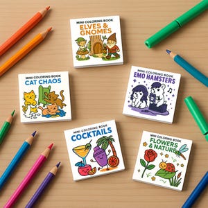 Six mini coloring books with cartoon cover art are arranged on a wooden table surrounded by colored pencils and markers.