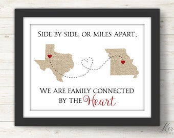 May include: A printable art print with a burlap texture featuring the outlines of Missouri and Texas with red hearts in the center of each state. The states are connected by a dotted line with a heart shape in the middle. The text reads "Side by side, or miles apart, We are family connected by the heart."