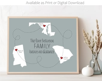 May include: A gray and white print with a map of the United States showing the states of Alabama, Maryland, and South Carolina. The states are connected by a dashed line. The text "The love between FAMILY knows no distance" is printed on the map. The names of family members are written next to red hearts on each state.