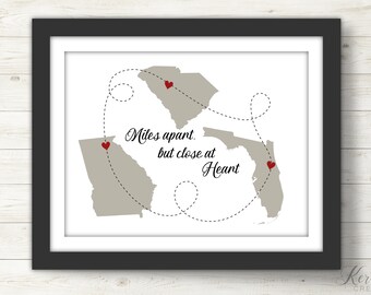 May include: A printable art print with a map of Georgia, South Carolina, and Florida. The states are connected by a dotted line with hearts marking the locations. The text "Miles apart, but close at heart" is written in cursive.