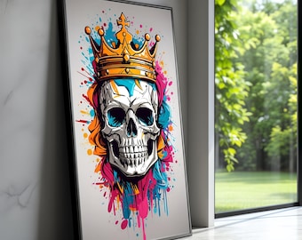 Puede incluir: Impresión artística enmarcada que presenta una calavera estilizada con una corona dorada. La calavera es blanca con cuencas de ojos y dientes negros, sobre un fondo de salpicaduras de pintura coloridas en azul, rosa, naranja y turquesa. La obra de arte está apoyada contra una pared.