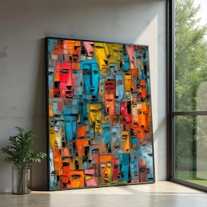 May include: A rectangular wall art piece featuring a dense, mosaic-style composition of numerous stylized human faces. The artwork uses a vibrant palette of bright orange, deep red, yellow, and various shades of blue, all enclosed in a thin black frame.