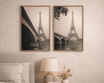 Puede incluir: Dos impresiones enmarcadas en tonos sepia de la Torre Eiffel en París. Una impresión muestra un puente en primer plano, la otra la torre con ramas de árboles. Ambas impresiones tienen un marco de madera y las iniciales "ea" en la esquina inferior.