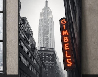 Puede incluir: Impresión enmarcada en blanco y negro del Empire State Building en Nueva York. La imagen incluye la palabra "GIMBELS" en naranja neón. La impresión captura una escena urbana clásica.