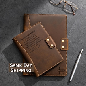 May include: Two brown leather journals with gold-tone snap closures. The smaller journal features the text: Difference Maker, An extraordinary person changing lives daily and inspiring the best in others. With wisdom and joy, they make the impossible possible. A gift to the world. See also: Elizabeth. The larger journal displays the letter E and the name Elizabeth. A silver pen and gold-rimmed glasses are included.