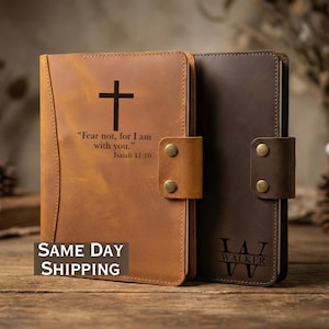 May include: Two leather journals, one tan and one dark brown, are displayed. The tan journal features a cross and the text "Fear not, for I am with you." Isaiah 41:10. The dark brown journal has the initials "JW" and the name "WALKER" below.