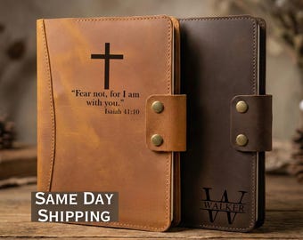 May include: Two leather journals, one tan and one dark brown, are displayed. The tan journal features a cross and the text "Fear not, for I am with you." Isaiah 41:10. The dark brown journal has the initials "JW" and the name "WALKER" below.