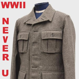 Puede incluir: Chaqueta de lana marrón con cuatro bolsillos delanteros y cuello. El texto "WWII NEVER USED" está impreso verticalmente en rojo en el lado izquierdo. La chaqueta tiene cierre de botones y una etiqueta en la manga.