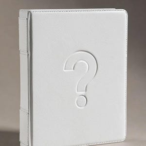 May include: A white, leather-bound book with a debossed question mark on the cover. The book has a textured surface and visible stitching along the edges. The spine features a reinforced design.