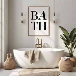 Könnte beinhalten: Ein modernes Badezimmer mit einer weißen ovalen Badewanne, einem gerahmten Druck mit dem Wort "BATH" und gewebten Körben. Ein beiges Handtuch liegt auf dem Wannenrand. Der Raum ist mit einer Pflanze und einem runden Teppich dekoriert.