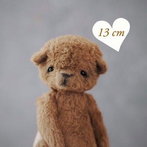 May include: A handmade brown teddy bear, approximately 5 inches tall, with a soft, textured appearance. The bear has a classic design with small, dark eyes and a sweet expression. The image includes the text "PDF PATTERN".
