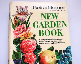 May include: A vintage Better Homes and Gardens New Garden Book with a colorful illustration of flowers, fruit, and vegetables on the cover. The book is a complete guide for roses, trees, lawns, shrubs, soils, landscaping, and construction.