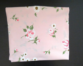 May include: Pink fabric with a floral pattern featuring white daisies and pink roses with green leaves.