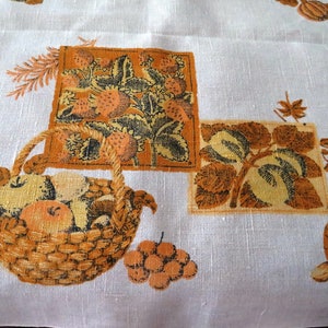 Puede incluir: Un mantel blanco con un patrón floral marrón y amarillo. El patrón incluye fresas, hojas y una cesta de fruta.