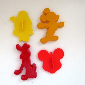 Könnte beinhalten: Vier Plastik-Ausstecher in Form von Mickey Mouse, Goofy und zwei verschiedenen Mickey Mouse-Köpfen. Die Mickey Mouse-Ausstecher sind orange, der Goofy-Ausstecher ist rot und die Mickey Mouse-Kopf-Ausstecher sind rot.