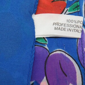 Może przedstawiać: Biała metka z tekstem "100% PO PROFESSIONAL MADE IN ITALY" na niebieskim i białym materiale z kolorowym wzorem owoc&oacute;w.