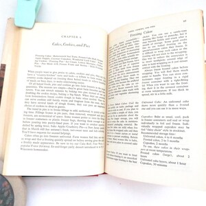 May include: An open vintage cookbook page titled Chapter 6: Cakes, Cookies, and Pies, featuring printed black text on off-white paper. The content provides instructions for freezing cakes, cookies, and pies, with a light blue clip at the top edge.