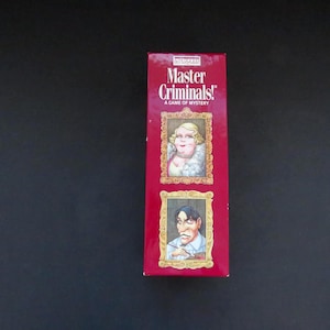 Puede incluir: Una caja roja para el juego "Master Criminals! A Game of Mystery" presenta dos retratos enmarcados de personajes de dibujos animados. El retrato superior es de una mujer, y el inferior es de un hombre. La caja está sobre una superficie negra.