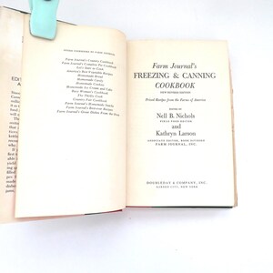 May include: An open hardcover book titled Farm Journal's Freezing & Canning Cookbook, edited by Nell B. Nichols and Kathryn Larson. The cream-colored pages feature black printed text, including a list of other cookbooks and publication details.