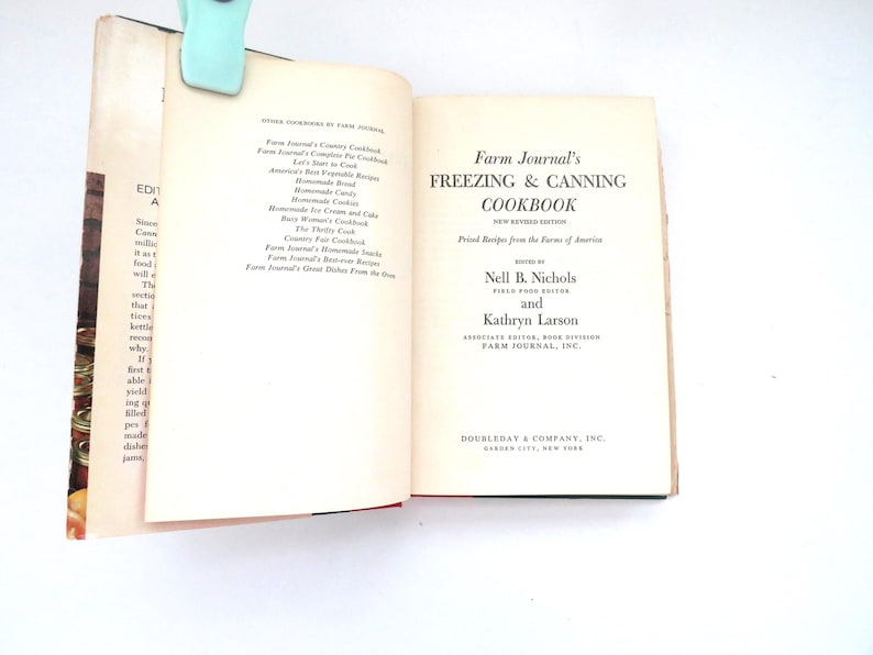 May include: An open hardcover book titled Farm Journal's Freezing & Canning Cookbook, edited by Nell B. Nichols and Kathryn Larson. The cream-colored pages feature black printed text, including a list of other cookbooks and publication details.