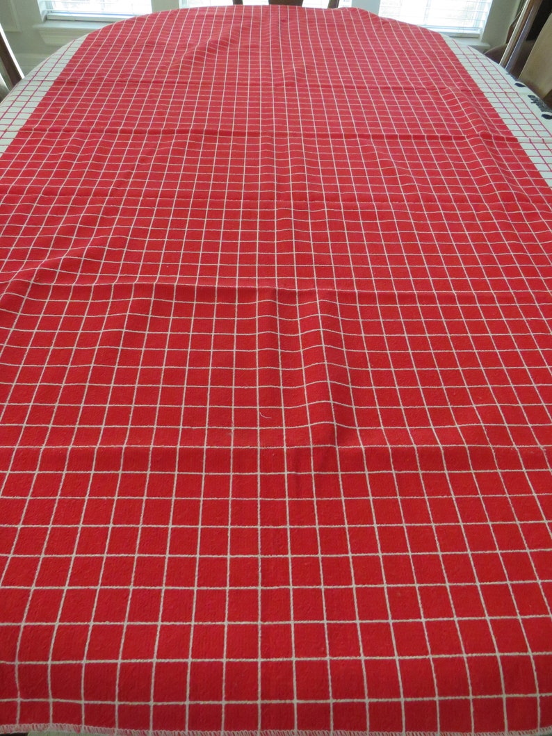 May include: Red and white checkered tablecloth with a white border. The tablecloth is made of a woven fabric and has a smooth texture.