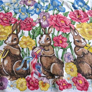 May include: Three brown rabbits playing musical instruments in a field of colorful flowers. The rabbit on the left is playing a trumpet, the middle rabbit is playing a tambourine, and the rabbit on the right is playing a violin.